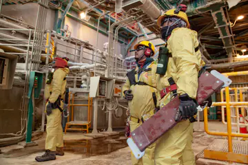 Operarios de Walvis con traje de protección química en planta minera