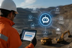 Trabajador con una tablet frente a una faena minera