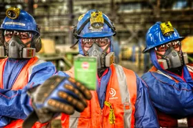 Tres trabajadores de Berliam con casco, lentes y respirador en una planta