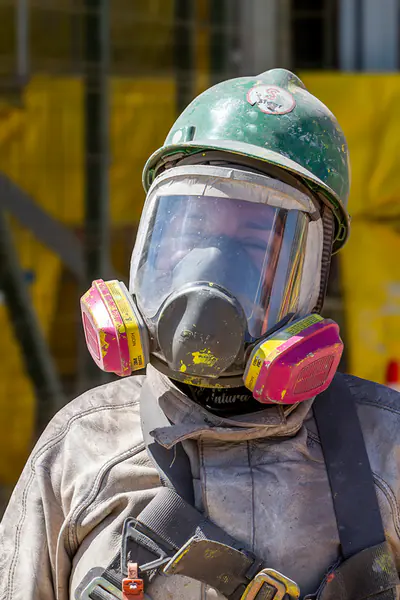 Trabajador de Veltis sonriendo en faena, con casco y protección auditiva